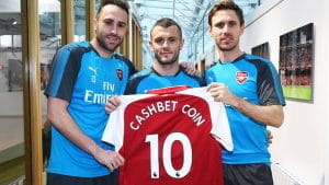 Arsenal players holding CashBet shirt