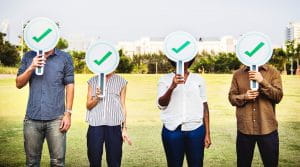 People standing with a tick in front of their face