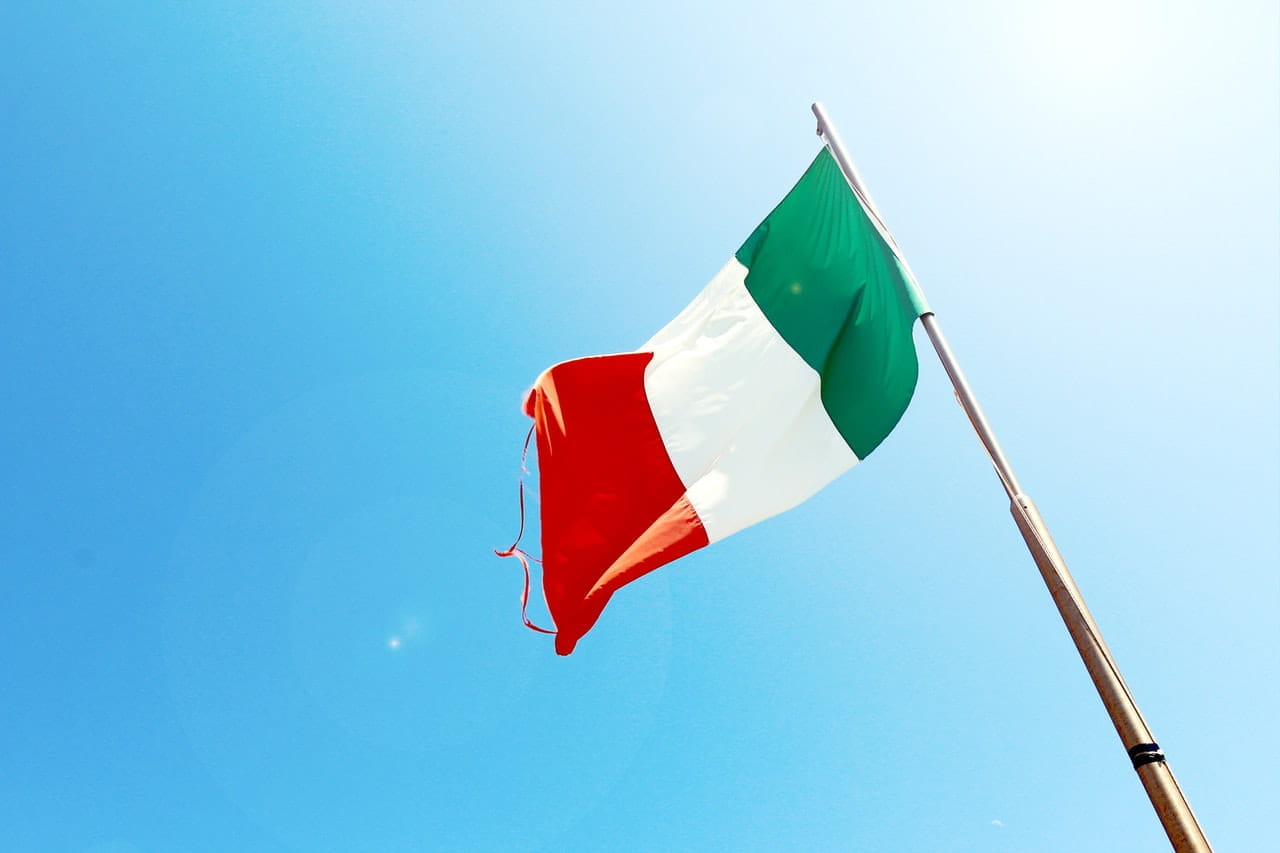 An Italian flag on top of the pole