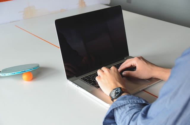 Hands typing on a laptop