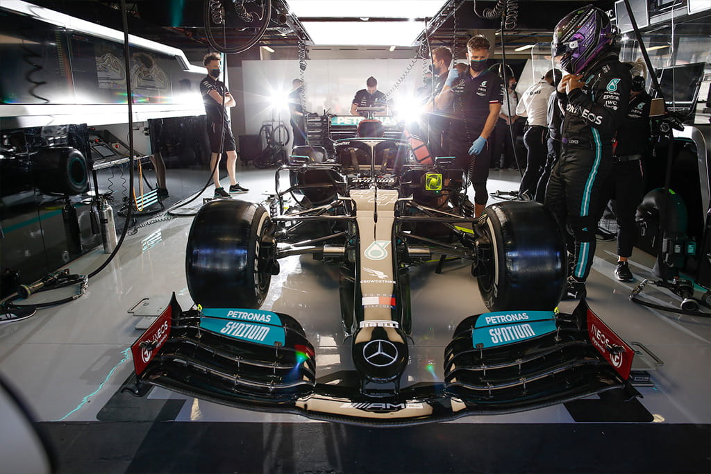 Mercedes’ F1 pit-crew look on at their car. 