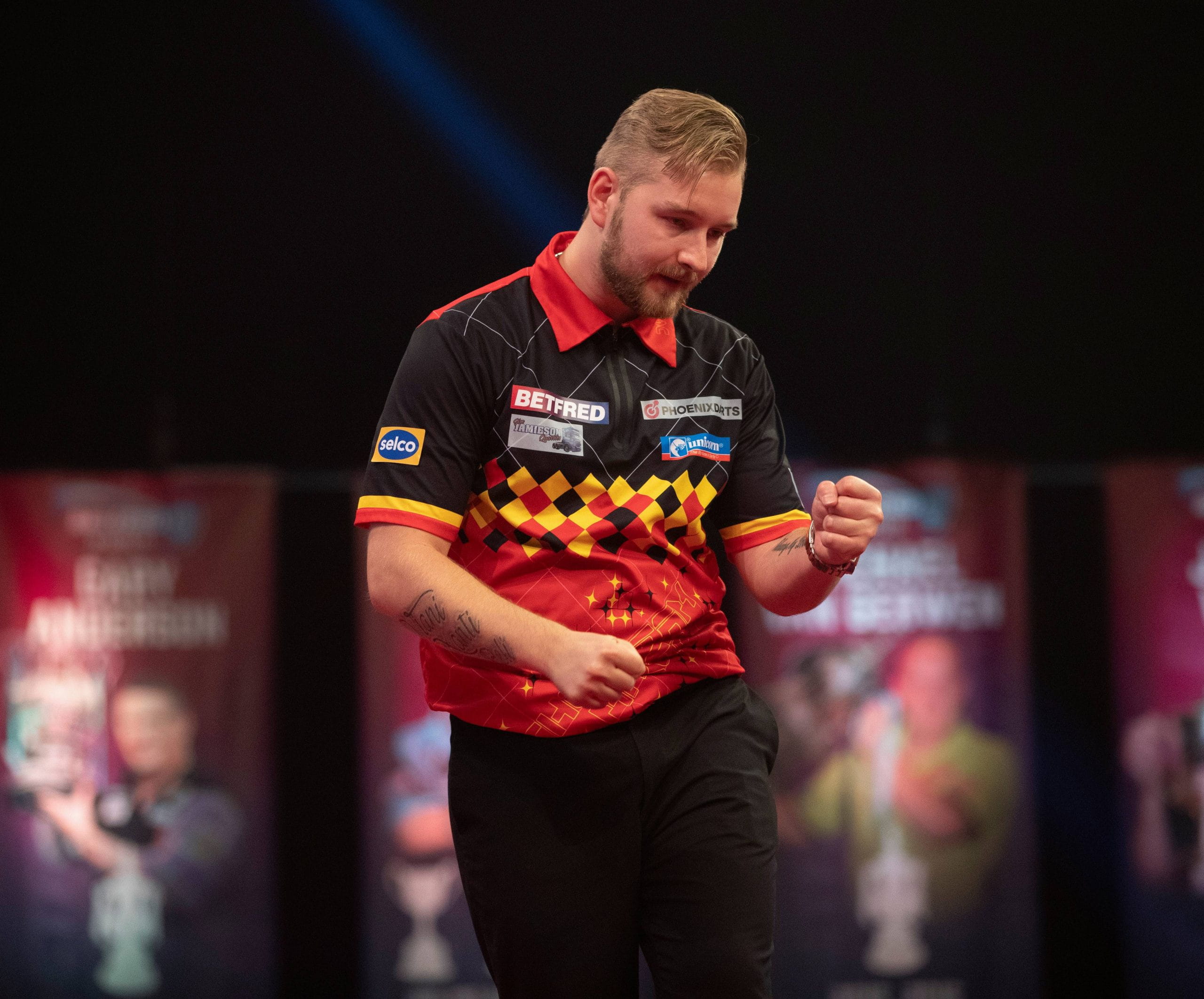 Darts player Dimitri Van den Bergh celebrating.