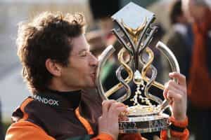 Grand National winning rider Sam Waley-Cohen kisses the national trophy.