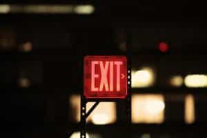 A picture of an exit sign near a door.
