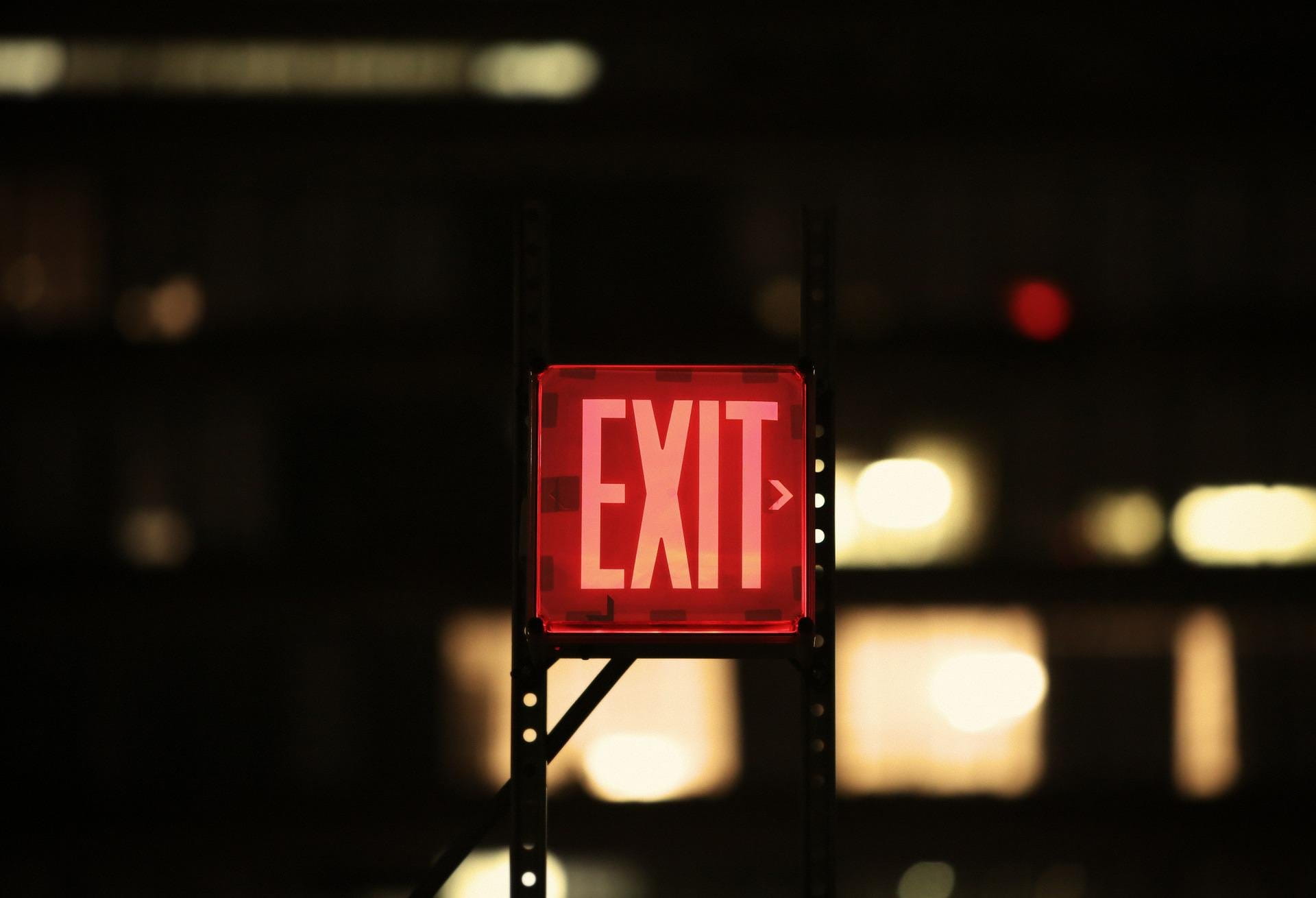 A picture of an exit sign near a door.