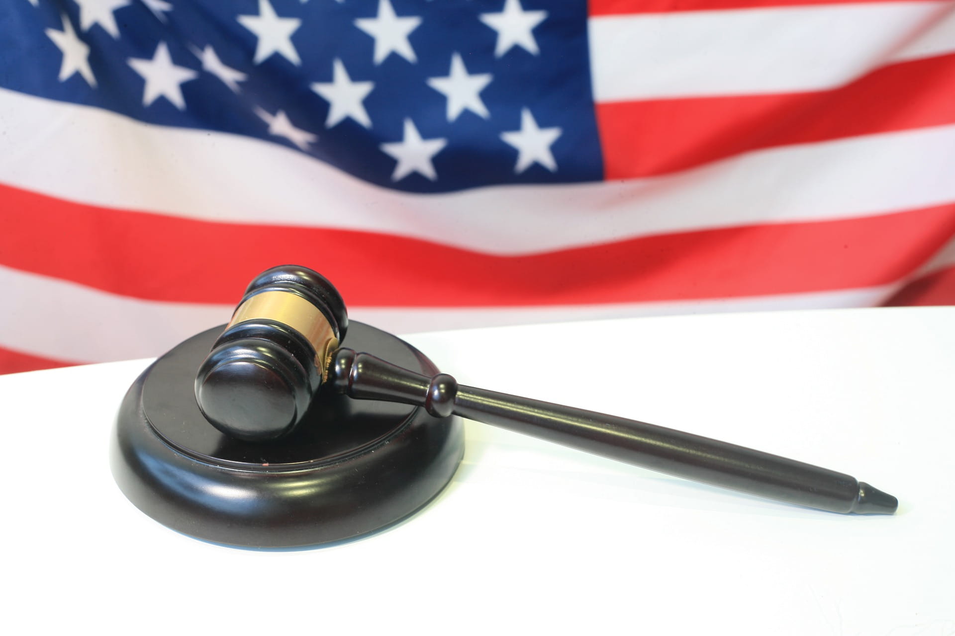 A picture of a courtroom gavel with an American flag in the background