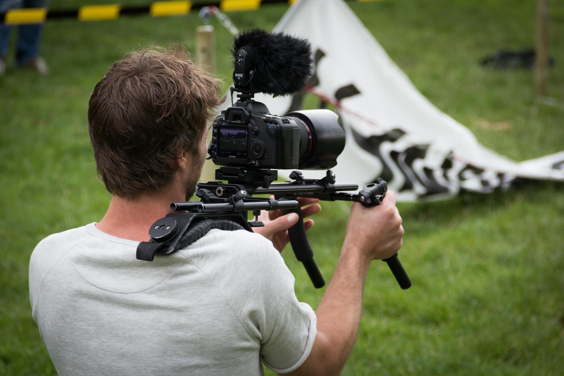 A picture of a camera man filming a TV commercial