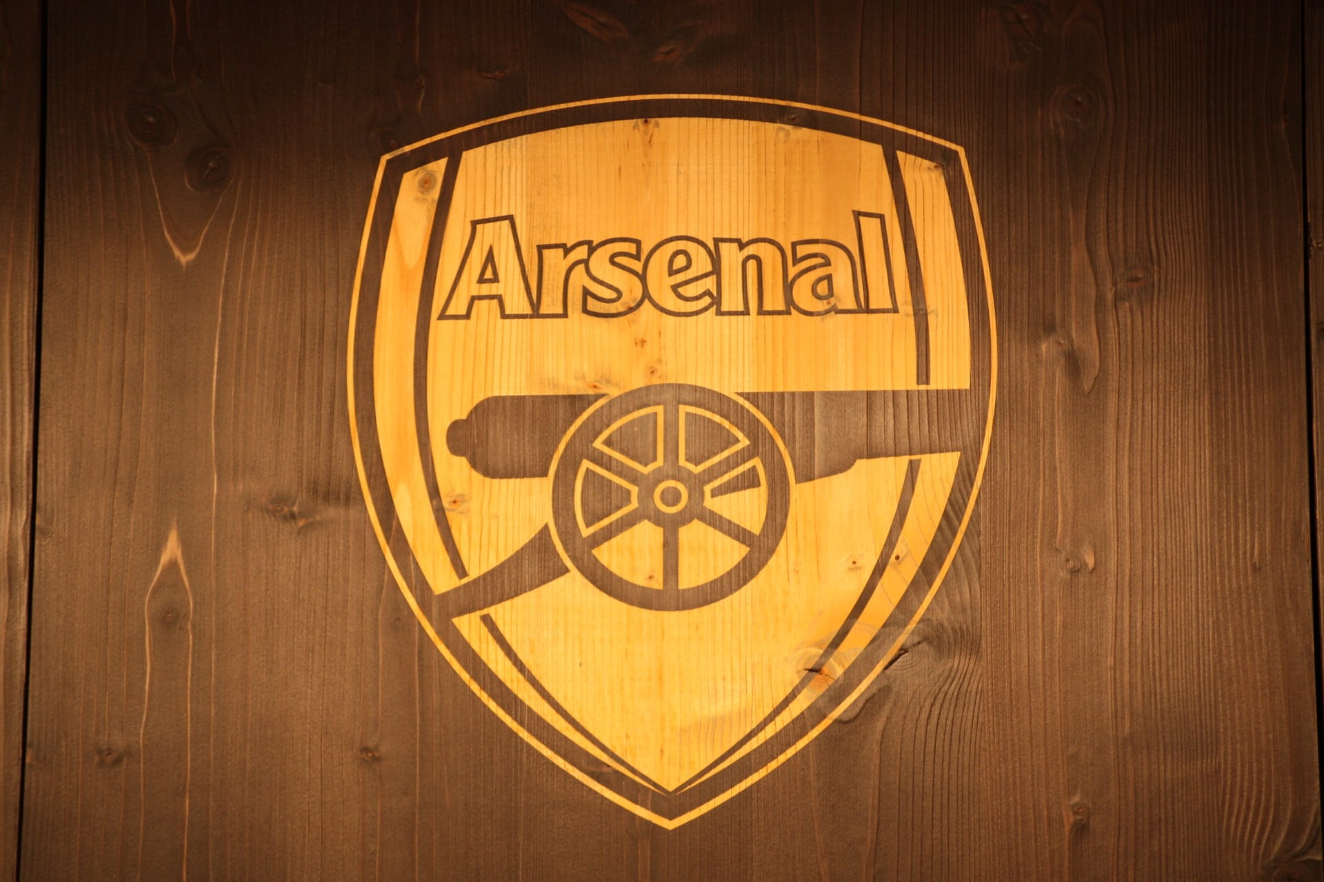Logo Arsenal di atas kayu sebagai latar belakang