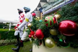 Christmas baubles in the foreground as jockeys enter the parade ring at Ascot.