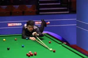 Liang Wenbo of China plays a shot during the 2021 World Snooker Championship.