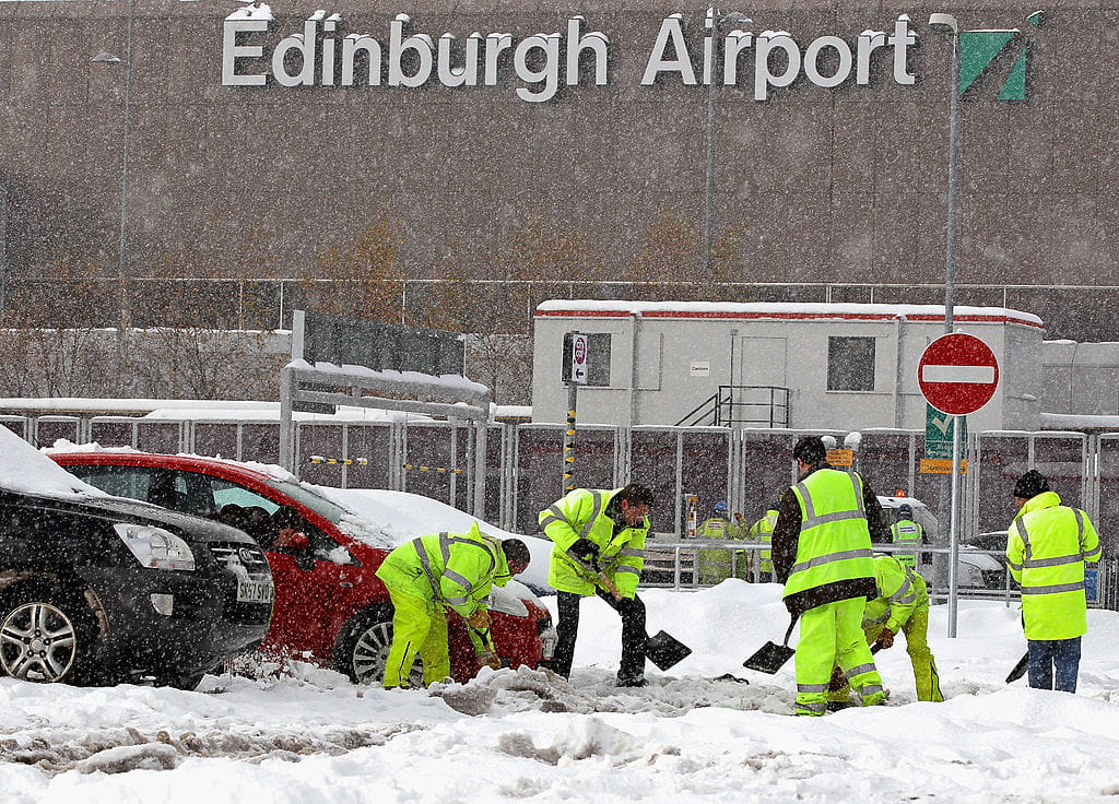 Pekerja membersihkan salju dari tempat parkir Bandara Edinburgh pada 1 Desember 2010, di Edinburgh, Skotlandia.