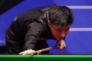 Zhao Xintong of China plays a shot during the Betfred World Snooker Championship, 2022.