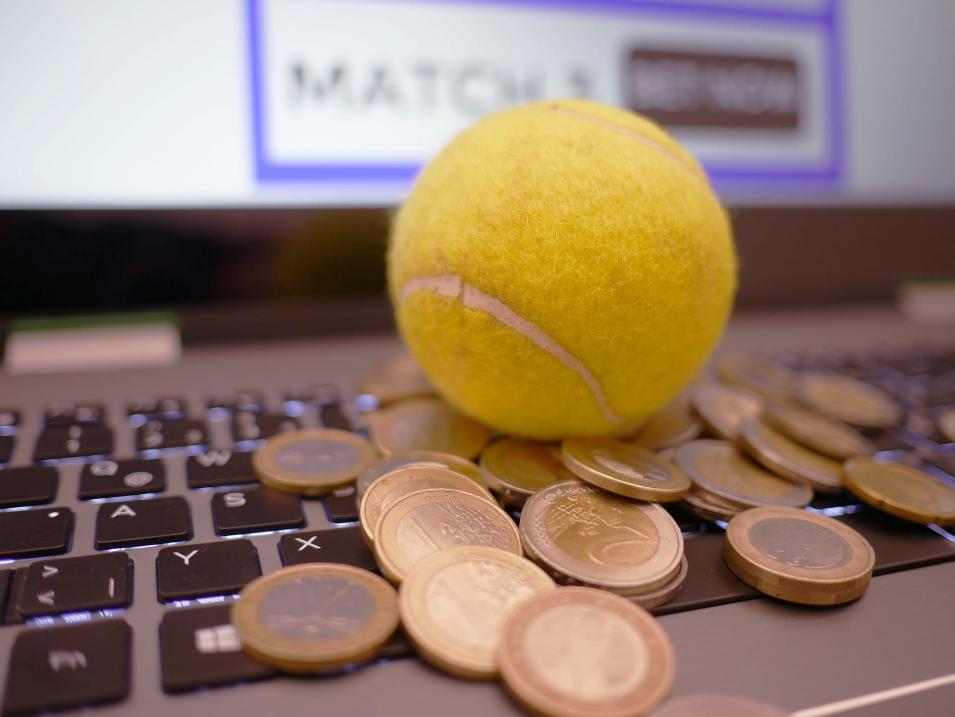 Gambar bola tenis di komputer dengan uang juga ditampilkan