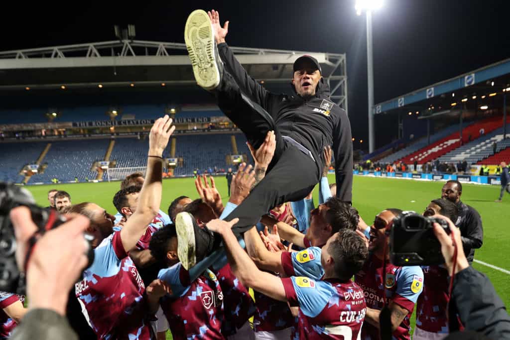 Vincent Kompany is lifted by his players after sealing the 2023 Championship at Ewood Park. 
