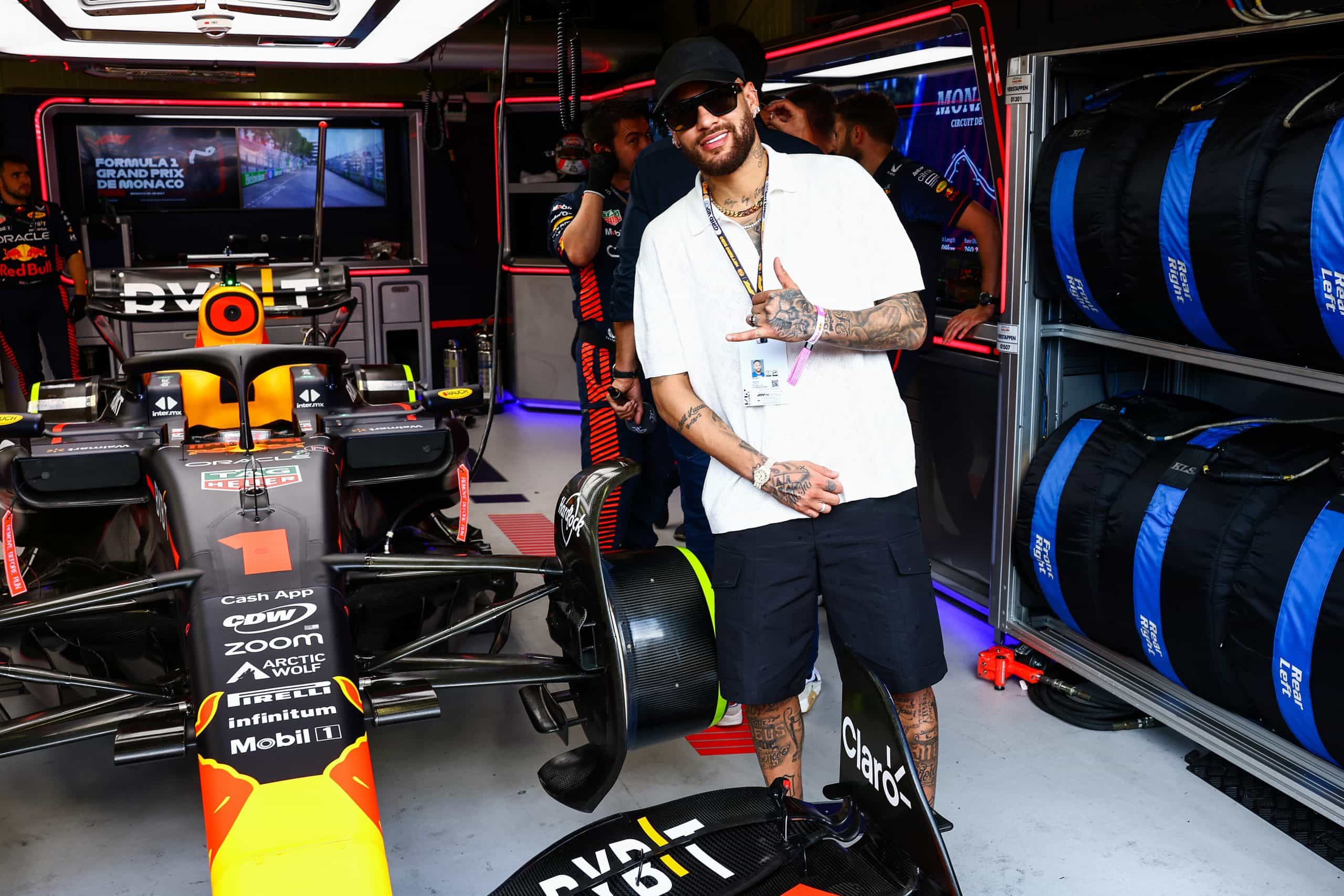 Footballer Neymar poses for a photo next to Max Verstappen’s F1 car at the 2023 Monaco Grand Prix.