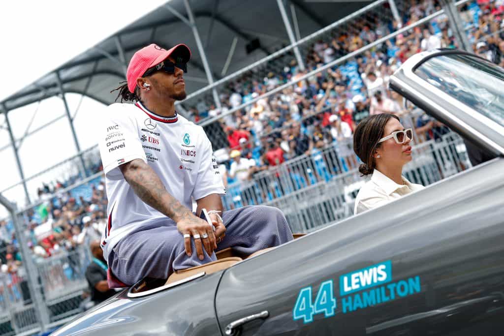 Lewis Hamilton waves to fans sat in a vintage car during the Miami 2023 race weekend.