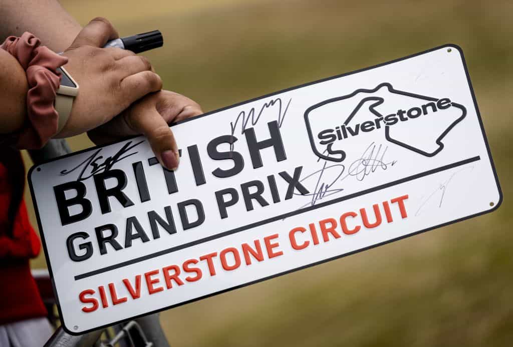 A fan holds a British Grand Prix number plate aloft hoping it will be signed by F1 drivers.