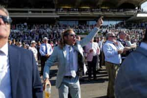 A racegoer cheers home a winner during day four of the 2022 Qatar Goodwood Festival.