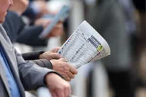 A punter checks the form in the Racing Post.