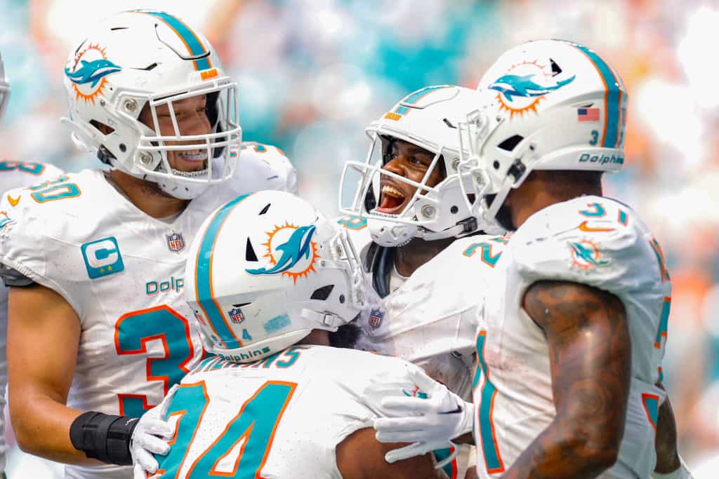 Miami Dolphins teammates celebrate a touchdown at Hard Rock Stadium.