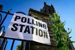 A polling station sign is outside Mackarness Hall in Honiton, England.