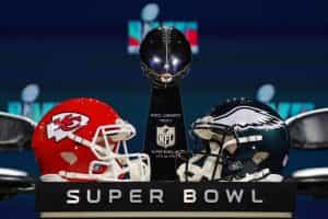 The Vince Lombardi Trophy alongside the helmets of the Kansas City Chiefs and the Philadelphia Eagles.