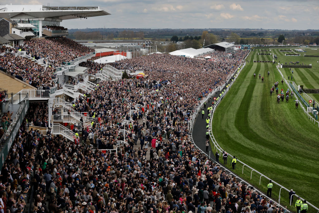 Huge crowds cheer on runners in a race during the 2023 Grand National meeting. 