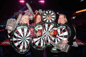 Four female darts fans enjoying a night at a Premier League fixture.