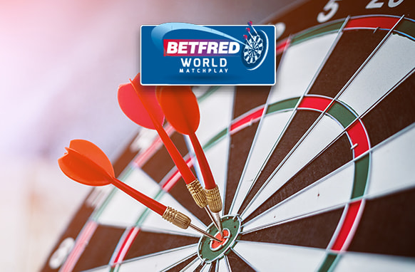 The image features a dartboard with three red darts accurately hitting the bullseye. Above the dartboard is the Betfred World Matchplay logo, indicating a connection to a notable darts competition. The scene highlights the precision and skill involved in the sport of darts.