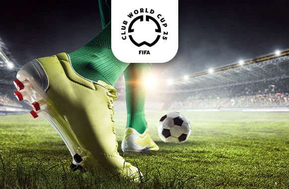 A striking close-up image of a footballer's yellow boots with red and black studs, set firmly on a green pitch, poised near a black-and-white football. The player wears green socks, and the background reveals a brightly lit stadium, capturing the energy of a live match. Above the scene, the FIFA Club World Cup 25 logo is displayed, indicating the significance of the event.