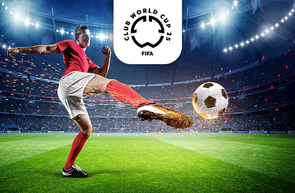 The image captures a football player wearing a red shirt and shorts energetically kicking a football inside a brightly lit stadium. Sparks fly as the ball is struck, emphasising the power and motion of the kick. Above the scene is the logo for the FIFA Club World Cup 2025, positioned prominently. The stadium is filled with an electrifying atmosphere, highlighting the intensity of the match.