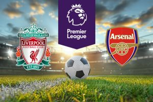 The image shows the logos of two Premier League football clubs, Liverpool and Arsenal, displayed on a football pitch background with a football placed at the centre. The Liverpool logo is on the left side, featuring a traditional crest design with elements such as the Liver bird and the text 