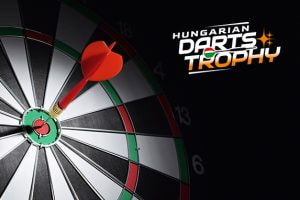 A close-up of a dartboard with a dart hitting the bullseye. On the right side, the text "Hungarian Darts Trophy" is displayed in bold white and orange letters.