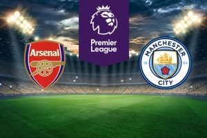 An illuminated football stadium backdrop. In the centre, a purple Premier League logo. On the left, the Arsenal Football Club emblem. On the right, the Manchester City Football Club emblem.