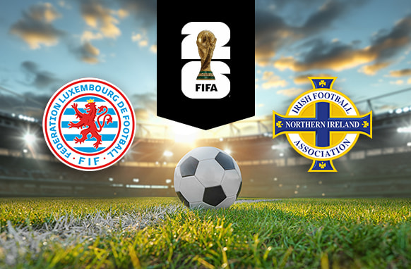 The image shows the logos of two national football associations, the Luxembourg Football Federation and the Irish Football Association (Northern Ireland), displayed on a football pitch background with a football placed in the centre. The Luxembourg logo is on the left side, featuring a red lion within a circular design, with the words "Fédération Luxembourgeoise de Football" and "FLF" written around the circle in red and blue. The Northern Ireland logo is on the right side, featuring a blue and gold cross with the text "Irish Football Association" and "Northern Ireland" integrated into the design. In the centre, above the football, there is the FIFA logo, consisting of the FIFA World Cup Trophy and the text "FIFA" below it on a black background. The backdrop depicts a football stadium with a dramatic sky, either during sunrise or sunset, creating a dynamic and compelling atmosphere.
