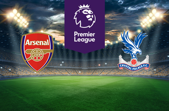 The image features two Premier League football team logos on a football pitch. On the left is Arsenal's logo, which features a cannon with the club's name above it on a red and gold shield-shaped badge. On the right is Crystal Palace's logo, displaying an eagle with its wings spread, perched on top of a football and the club's name below, with a ribbon and the year 1905 (when the club was founded). Above the logos in the centre is the Premier League logo with a stylised lion's head and the words "Premier League" on a purple background. The background shows a stadium with bright lights and a dramatic sky, creating an atmosphere of anticipation and excitement.