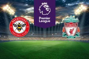 The image features two Premier League football team logos on a football pitch. On the left is Brentford's logo, which features a bee with the club's name and year of establishment (1889) encircling it on a red and white badge. On the right is Liverpool's logo, displaying a liver bird and the club's name, along with the motto "You'll Never Walk Alone" above it. The logo includes the year of foundation (1892) and decorative details. Above the logos in the centre is the Premier League logo with a stylised lion's head and the words "Premier League" on a purple background. The background shows a stadium with bright lights and a dramatic sky, creating an atmosphere of anticipation and excitement.