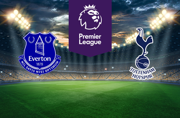 The image features two Premier League football team logos on a football pitch. On the left is Everton's logo, which is designed in blue and white and includes a tower, two laurel wreaths, and the club's motto "Nil Satis Nisi Optimum" (Nothing but the best is good enough). It also includes the club's name and year of establishment (1878). On the right is Tottenham Hotspur's logo, which features a cockerel standing on a football. The logo includes the club's name below it. Above the logos in the centre is the Premier League logo with a stylised lion's head and the words "Premier League" on a purple background. The background shows a stadium with bright lights and a dramatic sky, creating an atmosphere of anticipation and excitement.