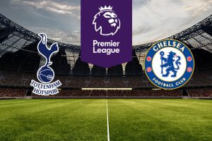 The image features the logos of two Premier League football teams on a football pitch. On the left is Tottenham Hotspur's logo, which features a cockerel standing on a football with the club's name below it. On the right is Chelsea's logo, displaying a circular crest with a lion holding a staff in the centre, surrounded by symbols including roses and the club's name, "Chelsea Football Club." Above the logos in the centre is the Premier League logo with a stylised lion's head and the words "Premier League" on a purple background. The background shows a stadium filled with seats and stadium lights, creating an atmosphere of anticipation and excitement as if awaiting a match.
