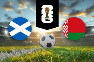 The image features two national football team logos on a football pitch. On the left, there is the flag of Scotland, featuring a white Saint Andrew's cross on a blue background. On the right, there is the flag of Belarus, consisting of a red and green horizontal field with a white and red traditional Belarusian pattern on the left. In the centre of the image, there is a football placed on the grass. Above the football, there is the FIFA World Cup logo with the FIFA trophy enclosed in a black vertical stripe, symbolising the tournament. The background depicts a stadium with dramatic lighting and a picturesque sky with scattered clouds, creating an atmosphere of anticipation and excitement.