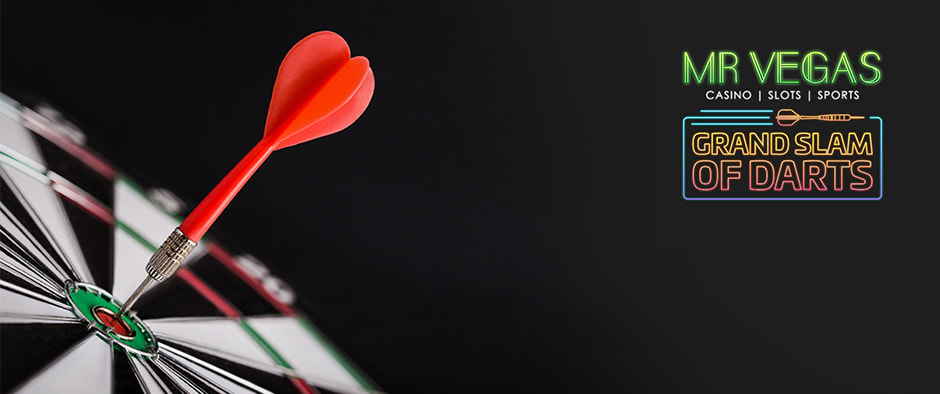 The image features a close-up of a dartboard with a single red dart hitting the bullseye, indicating a perfect throw. To the right of the dartboard, there are logos for "Mr Vegas Casino, Slots, Sports" and "Grand Slam of Darts." The background is dark, which makes the vibrant colors of the dart and the logos stand out, creating an atmosphere of precision and focus in the game of darts.