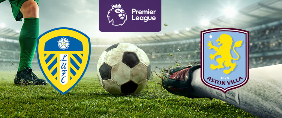 The image features logos representing two football clubs participating in a Premier League match. On the left is the logo of Leeds United, featuring a white rose and the initials "LUFC" over a shield. On the right is the logo of Aston Villa, which includes a lion and a star with the club's name and founding year. Above the logos is the Premier League logo, depicting a crowned lion's head with the text "Premier League" beneath it. The background shows a close-up of a football on a pitch, with players' legs in action, creating an atmosphere of competition and excitement within the stadium.