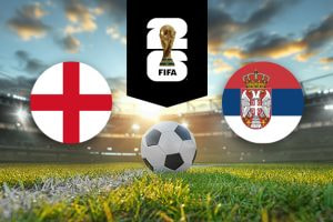 The image features flags representing two football teams participating in an international event. On the left is the flag of England, featuring a red cross on a white background, also known as St. George's Cross. On the right is the flag of Serbia, which consists of three horizontal stripes in red, blue, and white, with a coat of arms featuring a double-headed eagle and a crown. Above the flags is the FIFA 2022 World Cup logo, depicting the World Cup trophy. The background shows a brightly lit stadium at sunset with a football placed on the pitch in the centre, creating an atmosphere of competition and anticipation for the upcoming match.