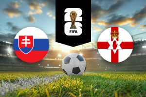 The image features flags representing two football teams participating in an international event. On the left is the flag of Slovakia, which includes horizontal stripes of white, blue, and red with a shield featuring a double cross atop three blue hills. On the right is the flag of Northern Ireland, featuring a red cross on a white background with a six-pointed star, a red hand in the centre, and a crown above. Above the flags is the FIFA 2026 World Cup logo, depicting the World Cup trophy. The background shows a brightly lit stadium at sunset with a football placed on the pitch in the centre, creating an atmosphere of competition and anticipation for the upcoming match.